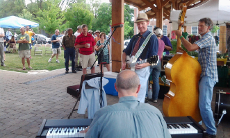 Local musicians play a variety of instruments, including a keyboard and bass, in an open space at the market.