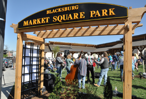 Crowds gather on the lawn underneath a sign that reads, “Blacksburg Market Square Park” on Market day.