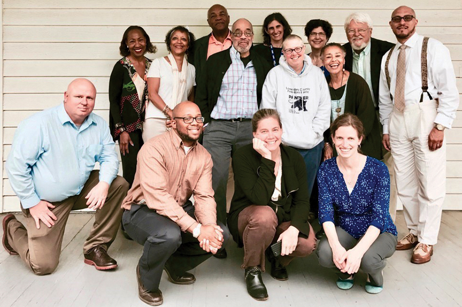 14 SNCC project partners pose for a photo on the porch at the Center for Documentary Studies.